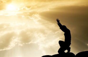 praying man on beautiful sky background