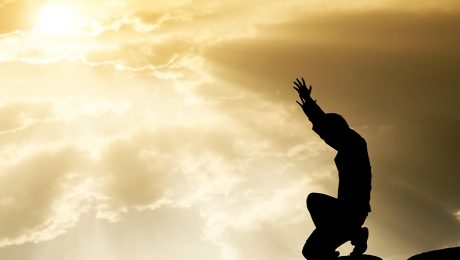 praying man on beautiful sky background